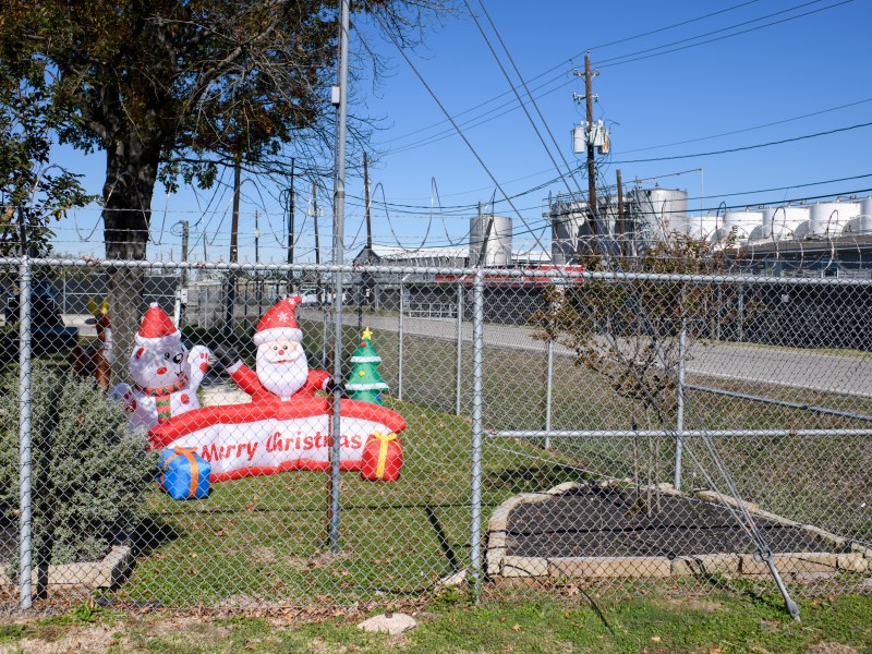 Christmas decorations are displayed behind a barbed-wire fence at K-Solv’s office in Channelview’s Jacintoport neighborhood. A row of tanks holding volatile chemicals at the company’s main facility sits just feet away.