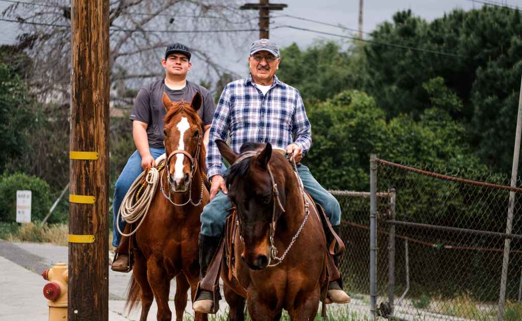 Benjamin and Damian Herrera, residents of Avocado Heights, ride their horses through the neighborhood.