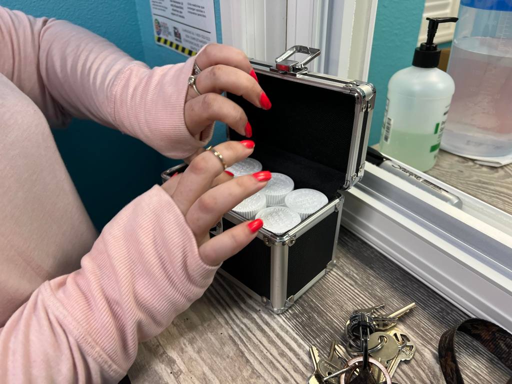 Stephanie puts her methadone refills directly into a lockbox, one of the facility’s pick-up rules.