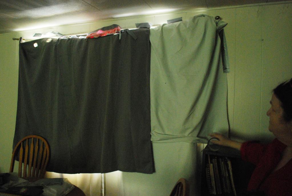 Lisa Gluskin, 68, shows the blankets and tape she uses to block out the heat from her living room window.